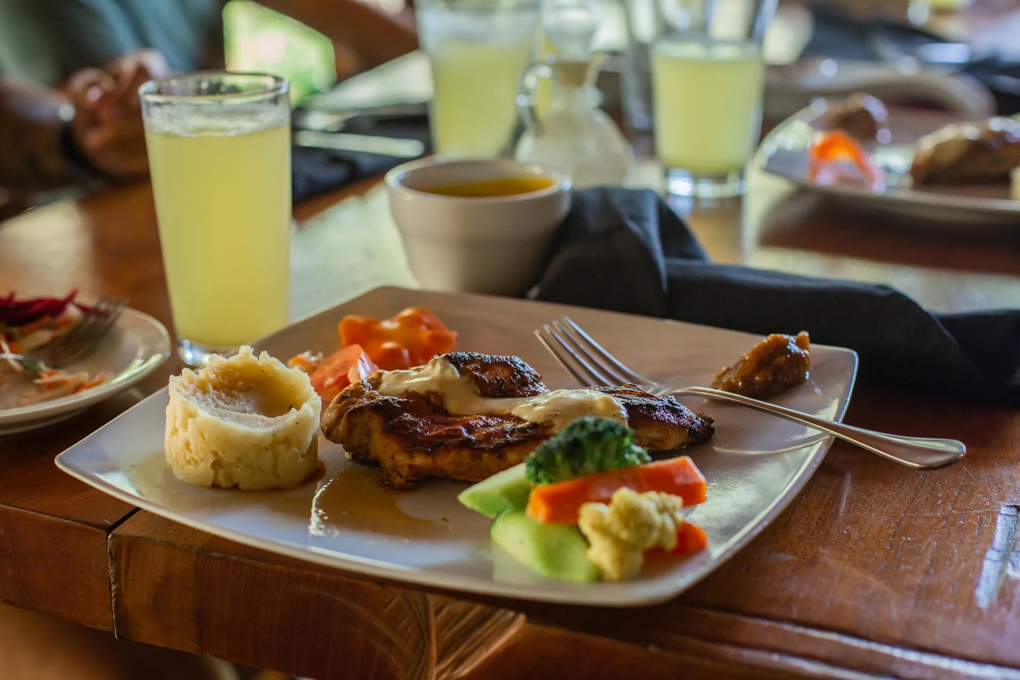 Plate with chicken, mashed potatoes, and mixed vegetables on a table.