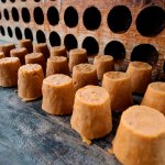Round blocks of brown sugar in rows on a wooden surface.