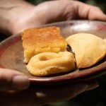 Plate with various baked goods held by hands.