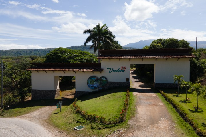 Entrance to Vandara National Park with a large gate and palm trees.